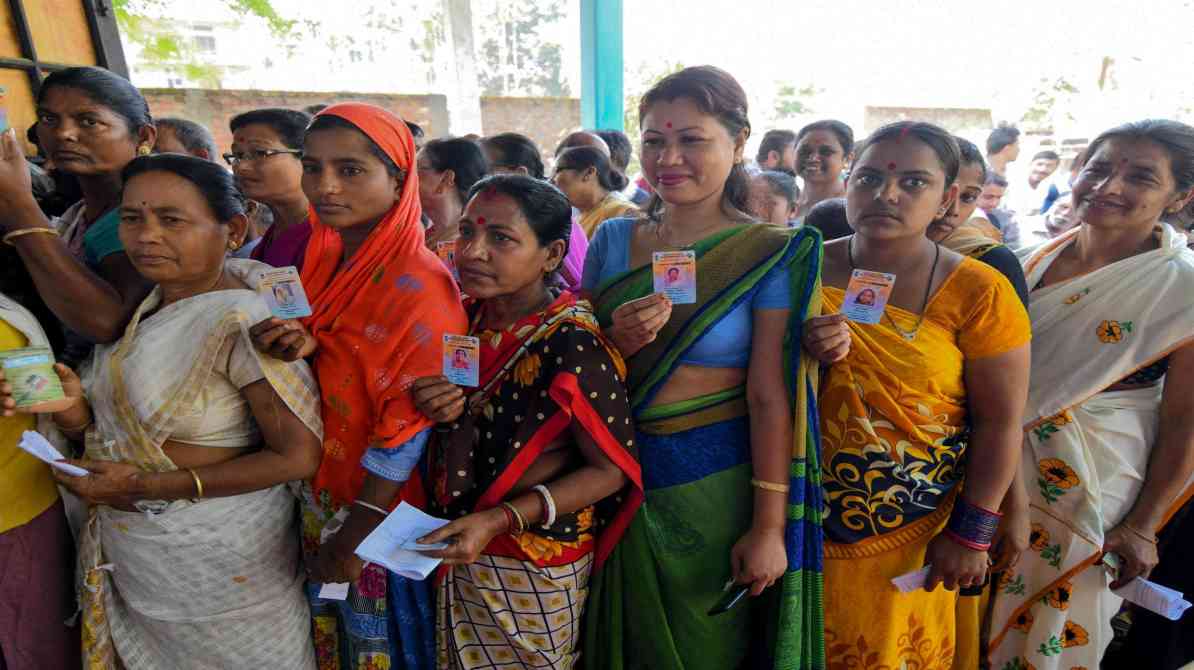 मतदान केंद्र पर वोट डालने के लिए खड़े लोग, लोकतांत्रिक भागीदारी का प्रतीक