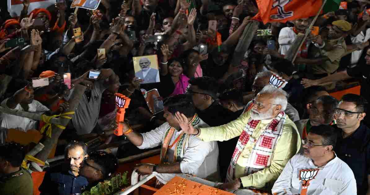 यह तस्वीर बंगाल चुनाव 2026 के दौरान आयोजित एक बड़ी चुनावी रैली को दर्शाती है, जिसमें नेताओं और जनता की भारी भागीदारी नजर आ रही है।