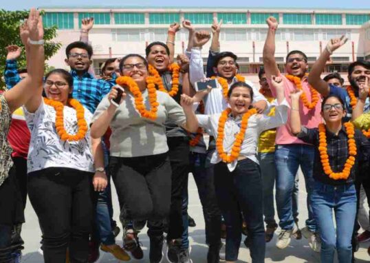 लैपटॉप और मोबाइल पर MP Board Result 2026 चेक करते हुए छात्र, आधिकारिक वेबसाइट के जरिए परिणाम देखते हुए।