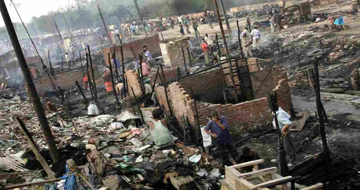 दिल्ली के रोहिणी क्षेत्र में रात के समय झुग्गियों में लगी आग, जहां दमकल विभाग आग बुझाने में जुटा है।