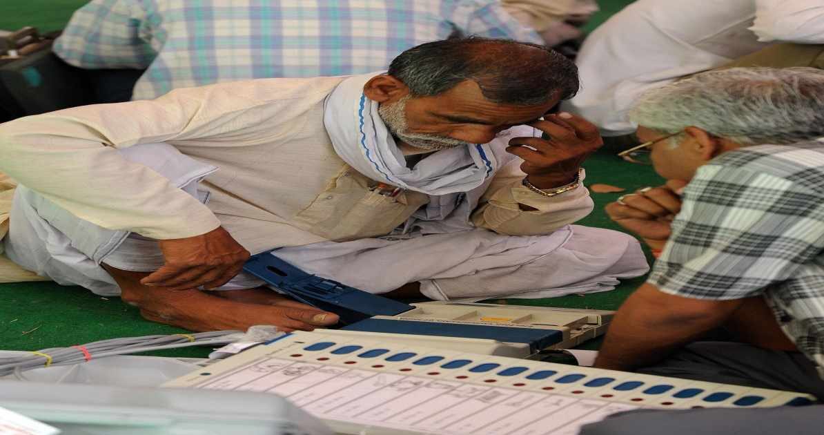 मतदान केंद्र पर ईवीएम मशीन की जांच करते अधिकारी, जहां बटन साफ और सुरक्षित दिख रहे हैं