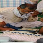 मतदान केंद्र पर ईवीएम मशीन की जांच करते अधिकारी, जहां बटन साफ और सुरक्षित दिख रहे हैं