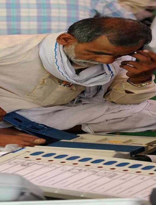 मतदान केंद्र पर ईवीएम मशीन की जांच करते अधिकारी, जहां बटन साफ और सुरक्षित दिख रहे हैं