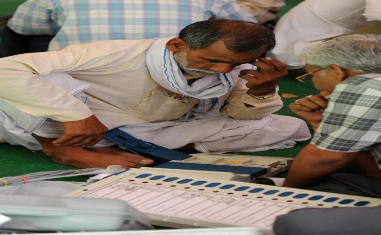 मतदान केंद्र पर ईवीएम मशीन की जांच करते अधिकारी, जहां बटन साफ और सुरक्षित दिख रहे हैं