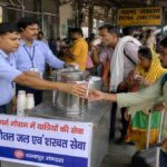 भीषण गर्मी के दौरान पटना जंक्शन प्लेटफॉर्म पर यात्रियों को शरबत और ठंडा पानी बांटते रेलवे कर्मचारी का दृश्य।